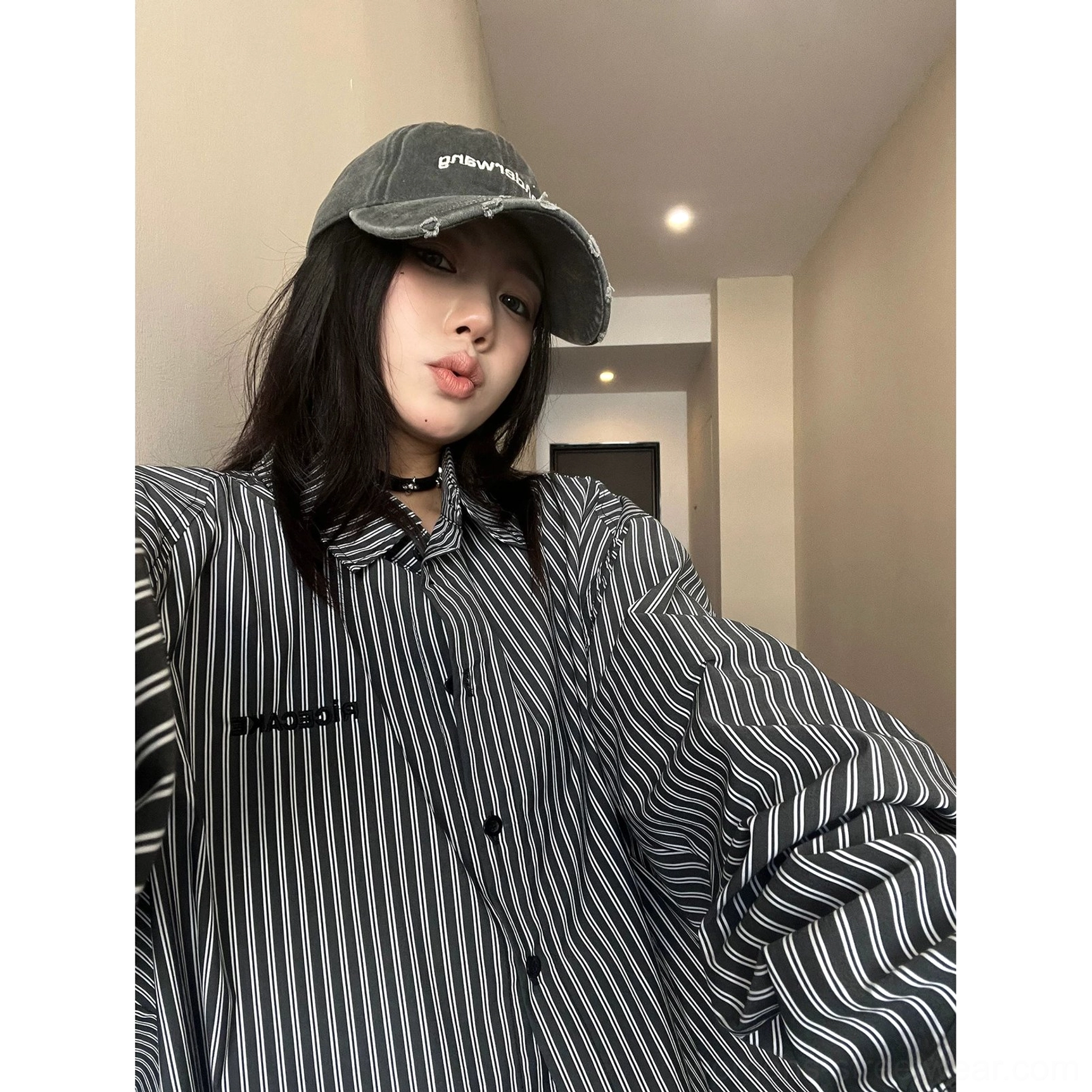 Close-up of pointed collar black buttons and narrow vertical stripe fabric on oversized cotton streetwear shirt