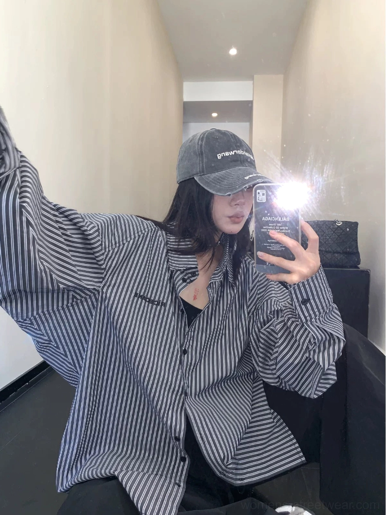 Front mirror view of black oversized vertical stripe cotton shirt styled open with a relaxed Korean streetwear silhouette