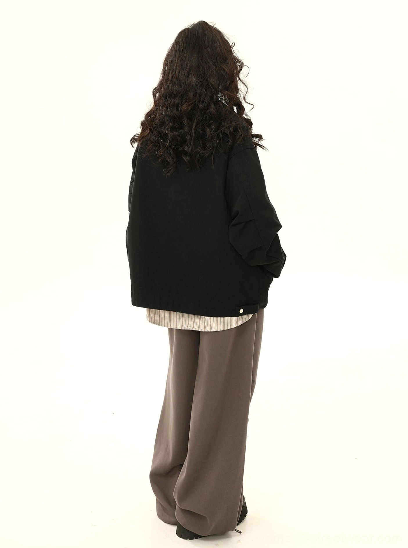 Back view of a black oversized vintage cargo work jacket showing its clean minimalist back design, relaxed hem, and loose streetwear silhouette