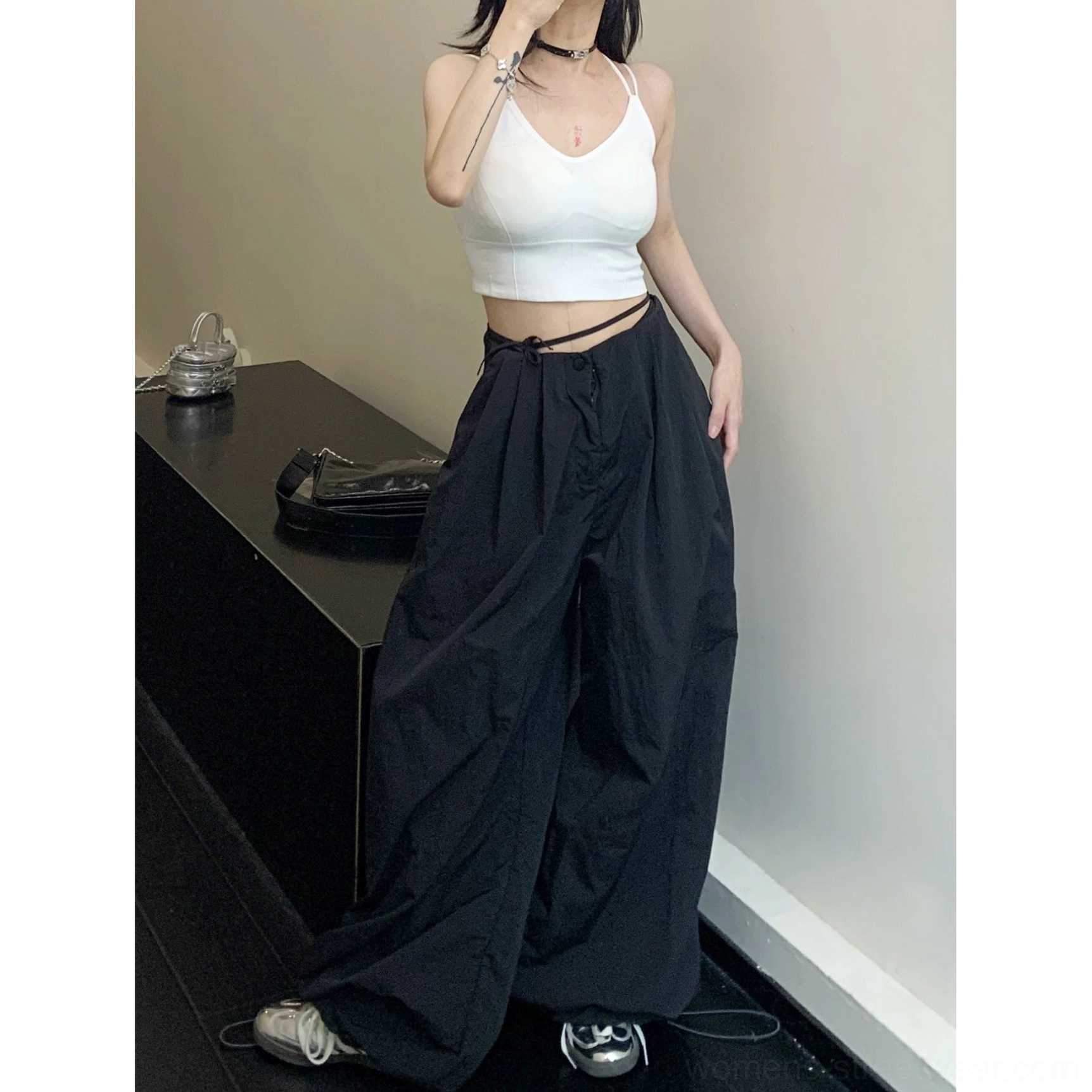 Black parachute wide-leg pants product detail showing the relaxed drawstring waist and oversized streetwear proportions