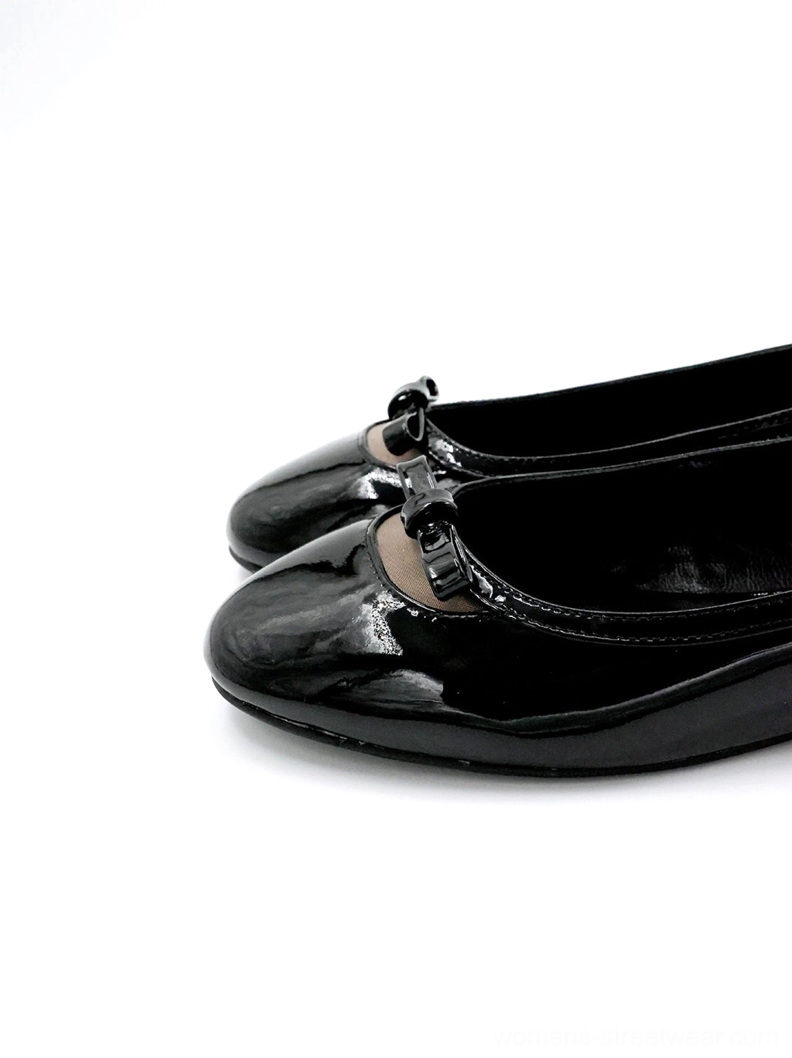 Black patent leather ballet flats viewed from the front side featuring a shiny rounded toe, bow ornament, flat sole, and Korean streetwear styling