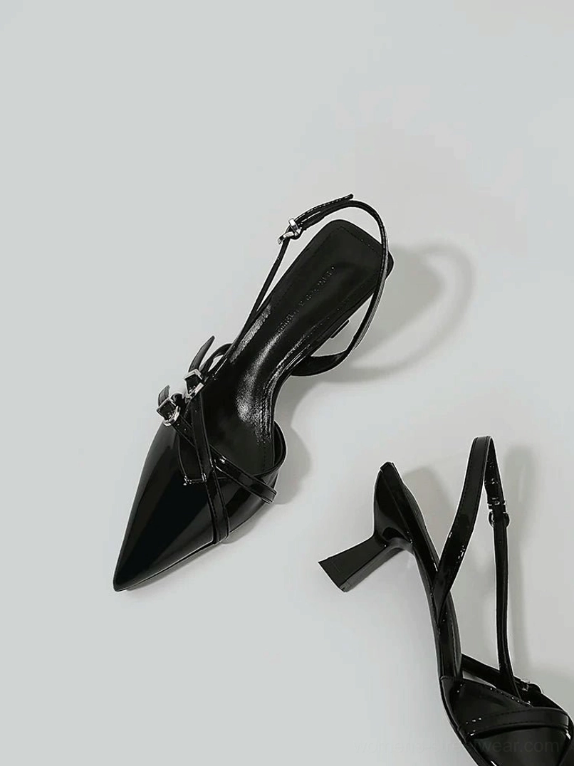Side detail view of black buckle slingback kitten heel showing glossy pointed toe, silver buckle and open back strap