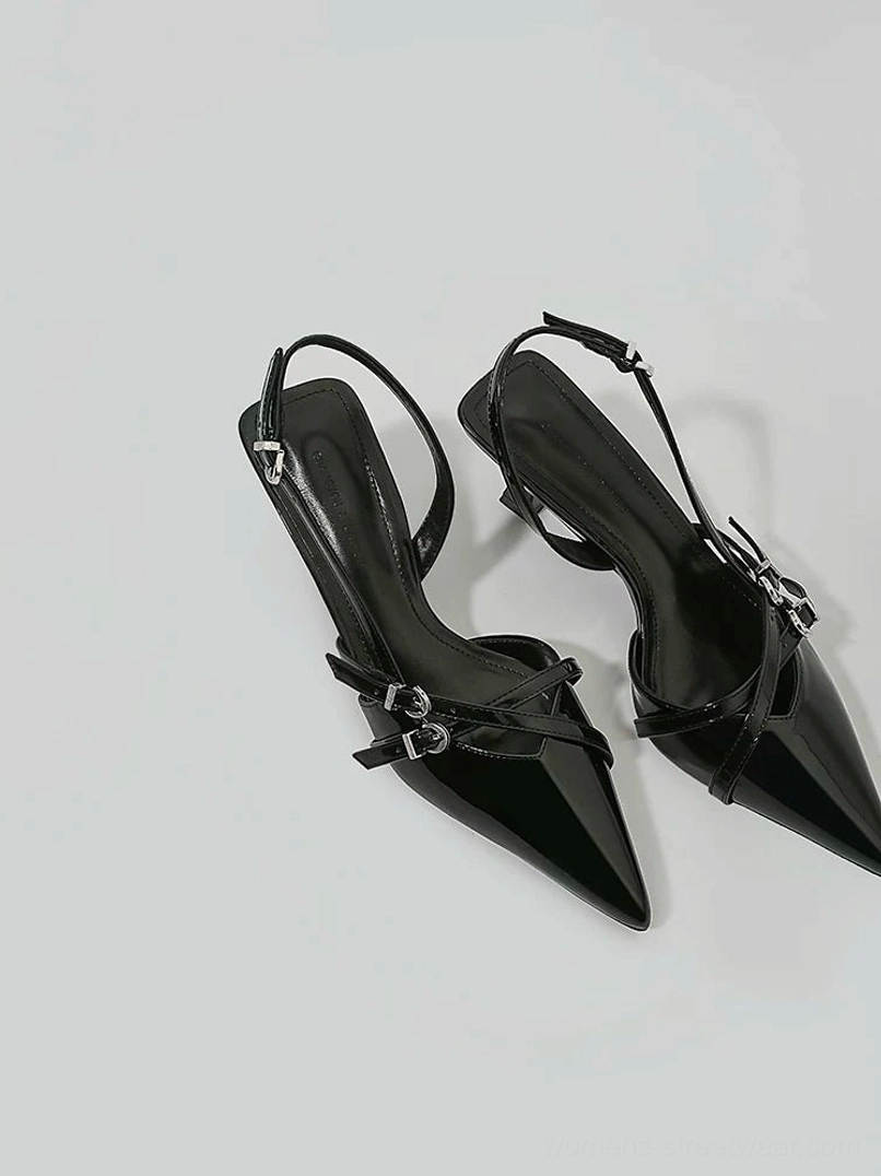 Top view of black glossy buckle slingback kitten heels with pointed closed toes and crossed silver buckle straps