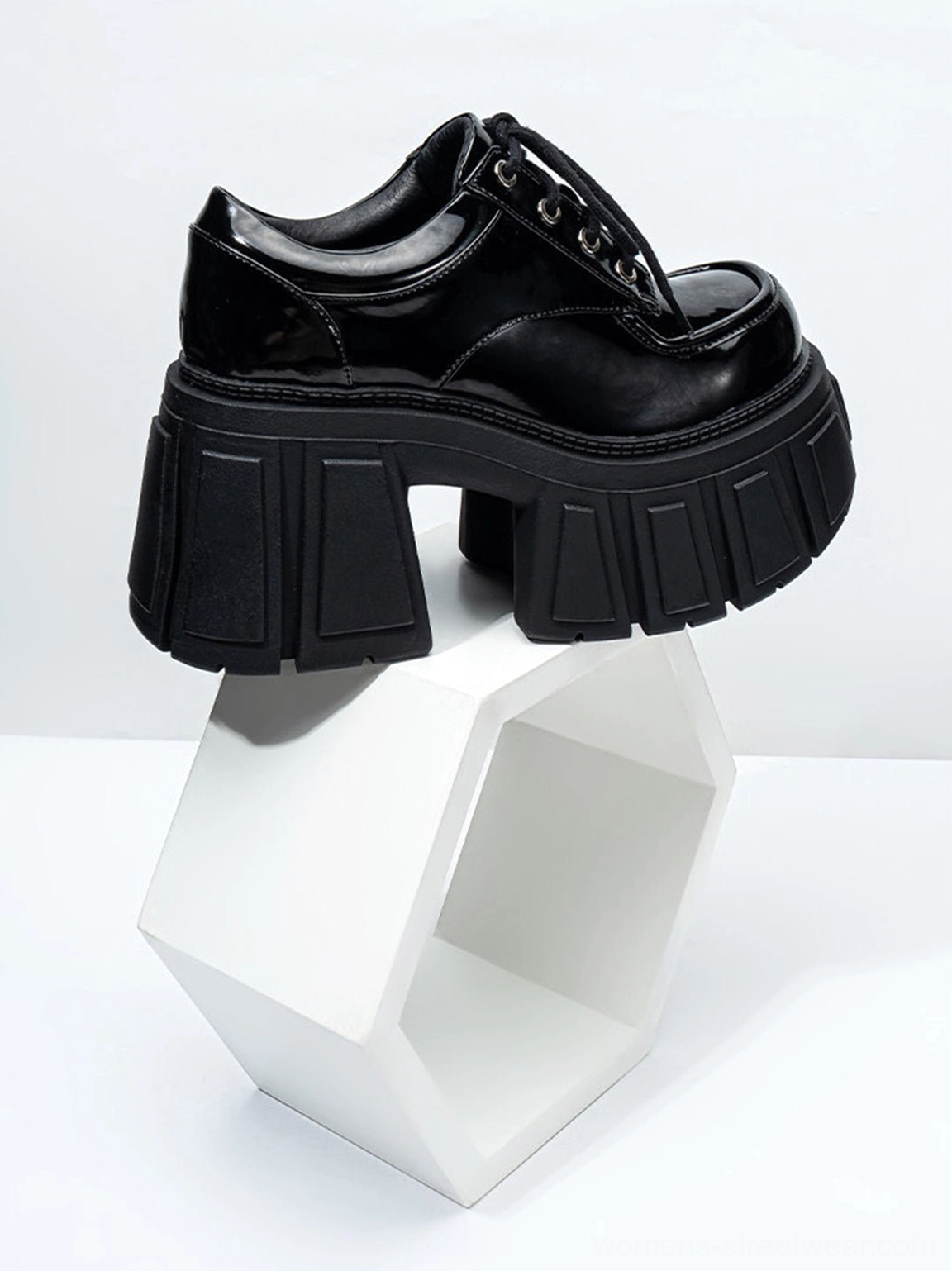 Rear three-quarter view of black patent chunky platform derby shoe with structured heel and grooved platform outsole