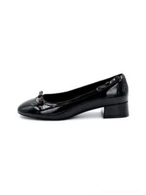 Side profile of black patent leather Mary Jane pumps with bow detail, buckle strap, rounded-square toe, and low block heel