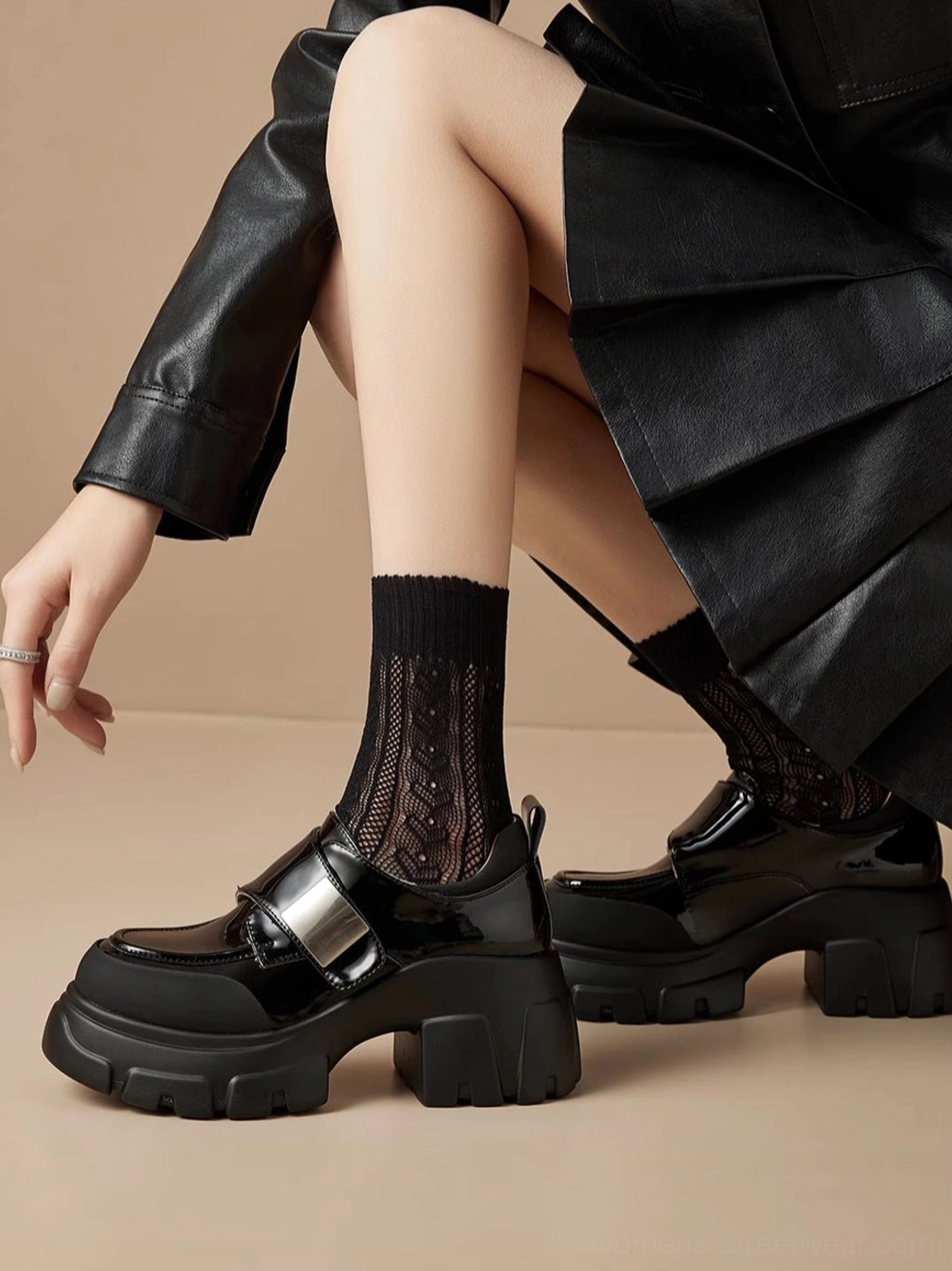 Close-up of black patent platform Mary Jane shoes worn with fishnet socks and alternative streetwear styling