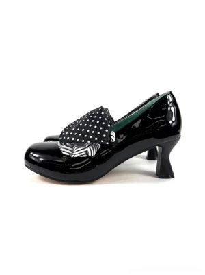 Black patent polka dot bow mid-heel pumps in side view with glossy finish, rounded toe, striped bow trim and dark green insole
