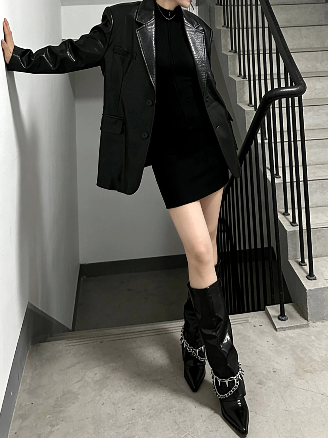 Full-body streetwear look featuring black patent spiked chain mid-calf punk wedge boots and black leather outfit