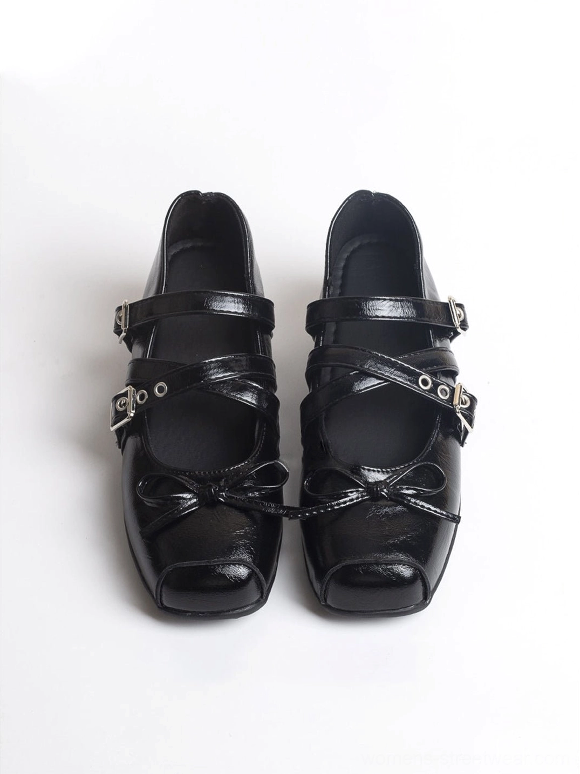 Front view of black patent leather square-toe Mary Jane flats with front bow and layered buckle straps