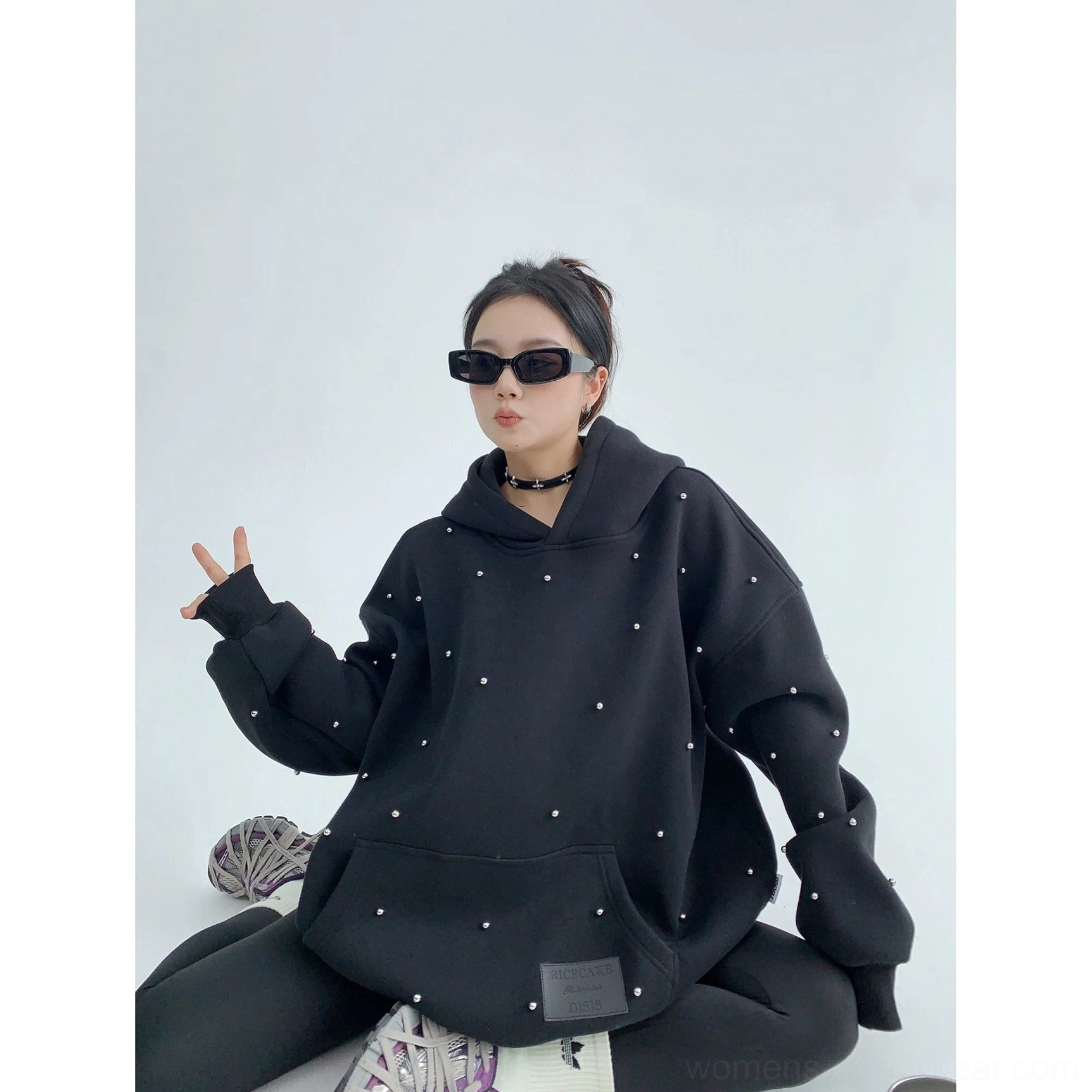 Black pearl-embellished oversized hoodie styled with black leggings, white socks, sneakers, and a front kangaroo pocket
