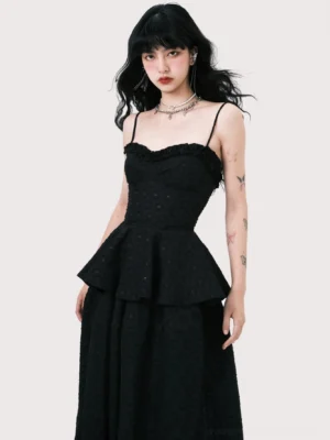Close-up view of black peplum camisole dress top showing ruffled sweetheart neckline fitted bust and subtle dotted jacquard texture