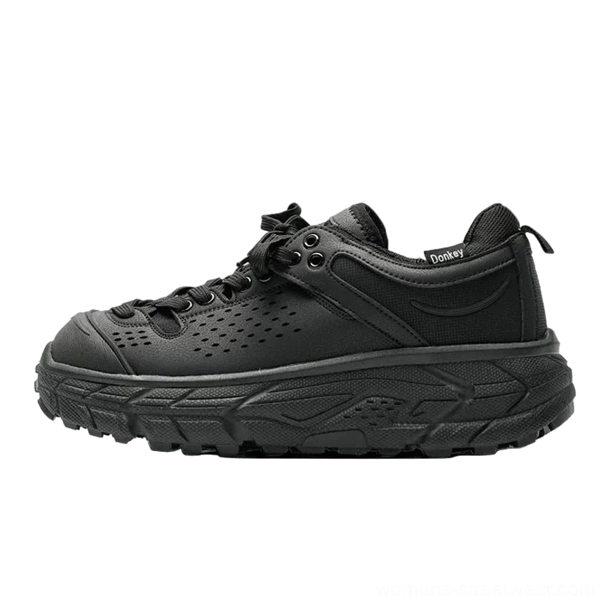 Side profile of a black perforated utility outdoor trainer with heel label lace-up design and thick deep-lug anti-slip outsole