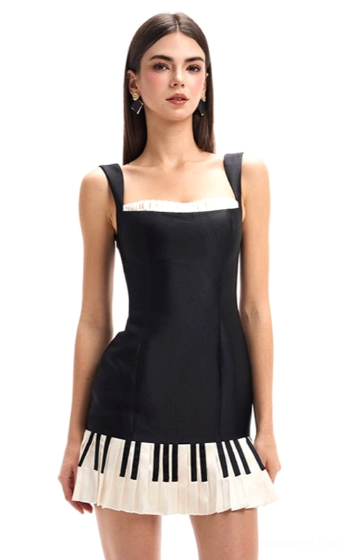 Studio view of black piano keys mini dress featuring satin-like fitted bodice white ruffled neckline and pleated piano print skirt