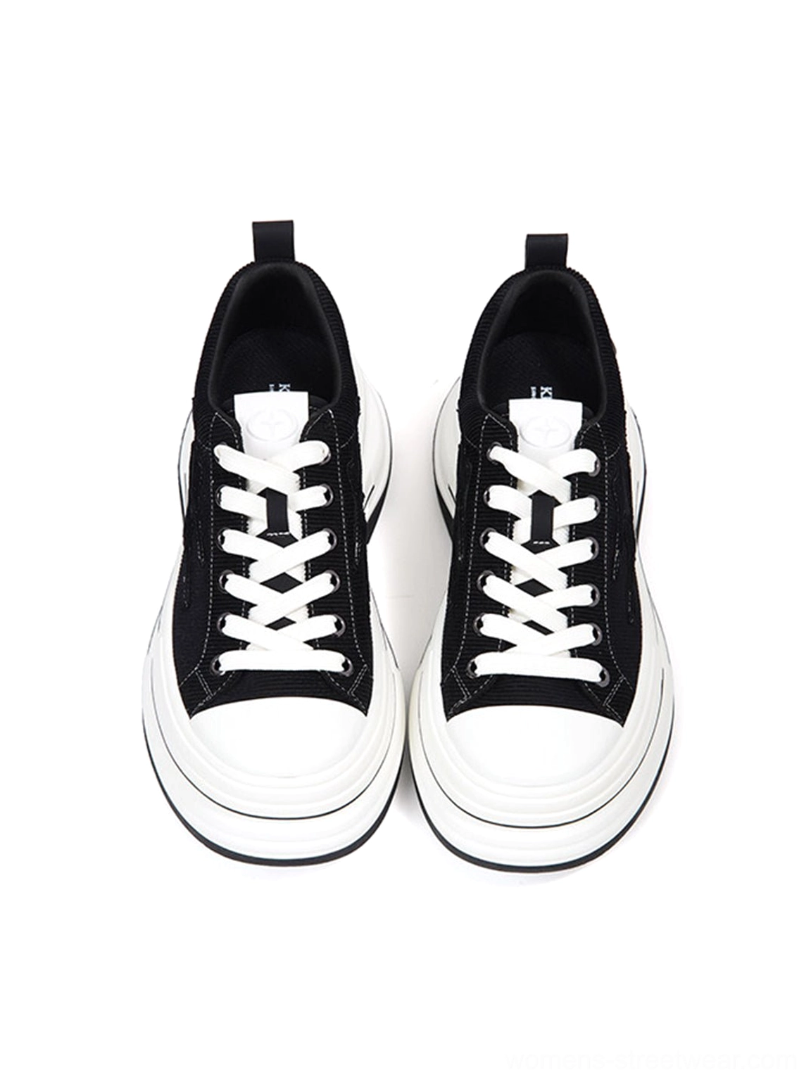 Front view of black low-top platform canvas sneakers with round rubber toe caps, white flat laces, and double-layer white sole