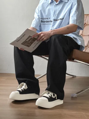 Black and white chunky platform sneakers styled with black wide-leg pants in a casual indoor streetwear outfit