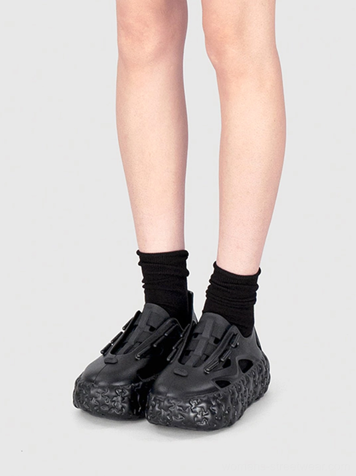 Close-up of black platform sandals with ankle socks front toggle fastener closed-toe shape and star-textured outsole