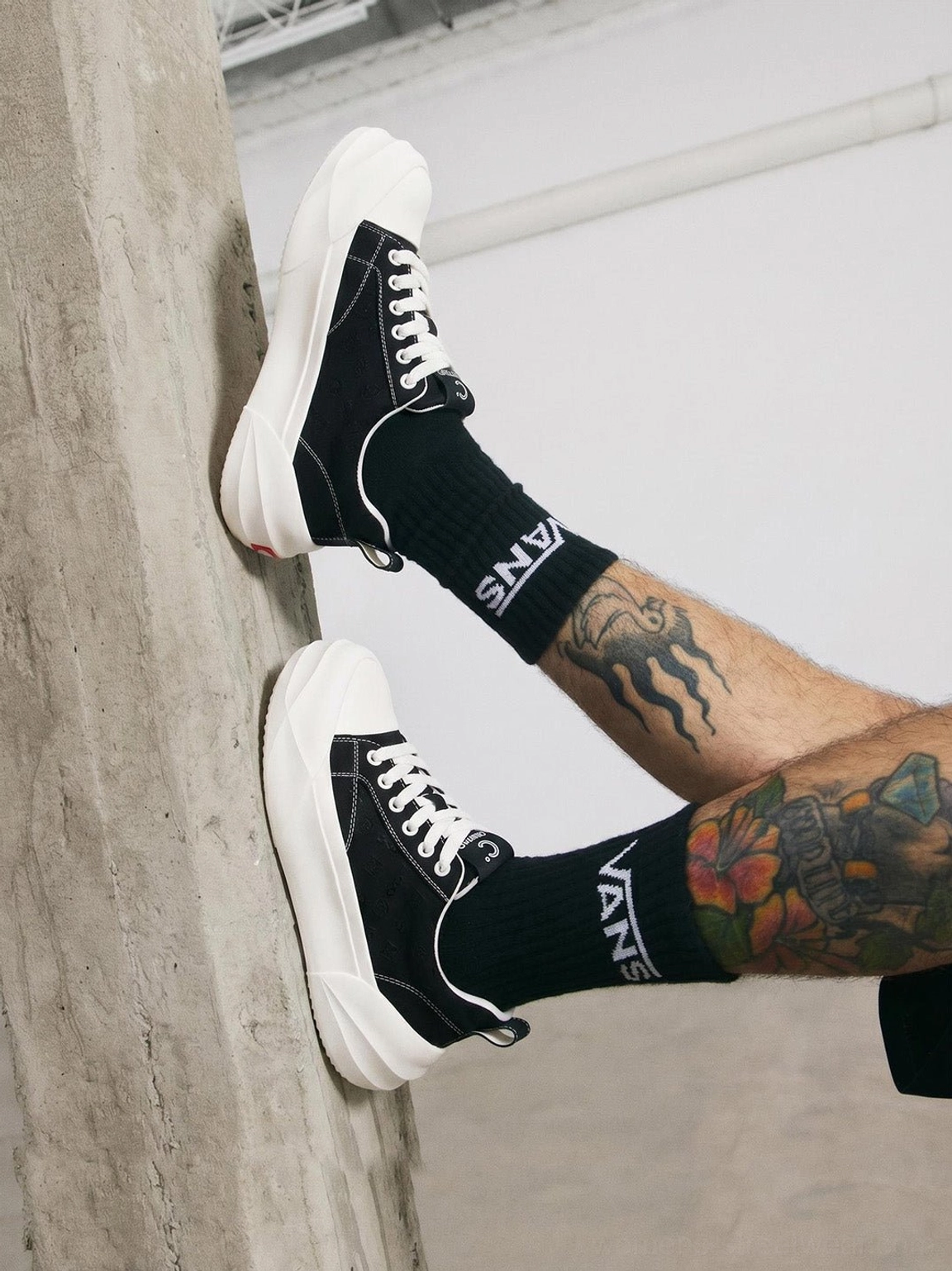 Side view of black low top platform skate sneakers with white toe cap and thick sole
