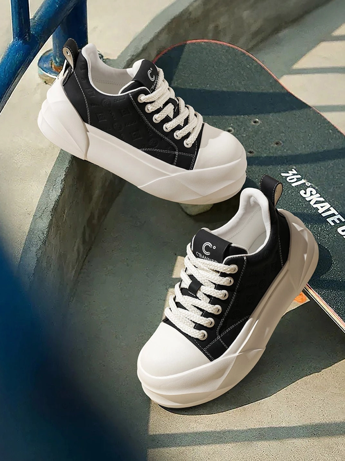 Black platform skate sneakers with geometric white sole displayed on skateboard at skatepark