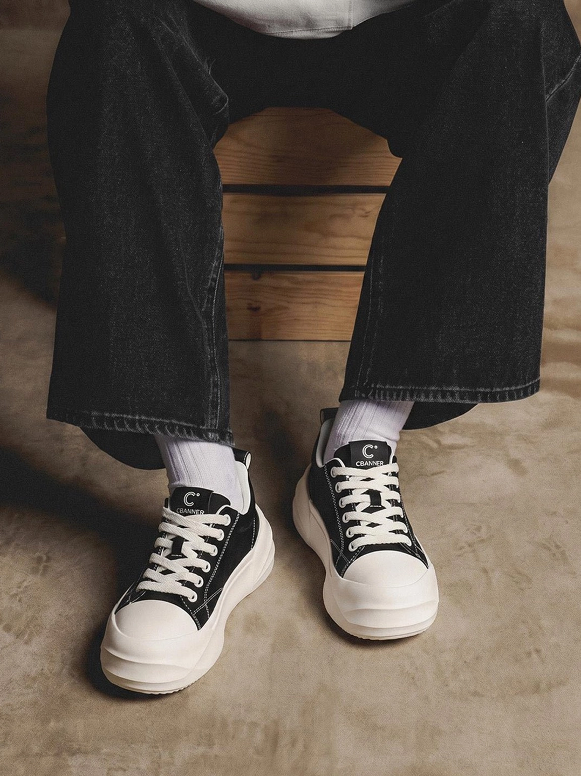 Black and white geometric sole platform skate sneakers worn with dark jeans in urban setting