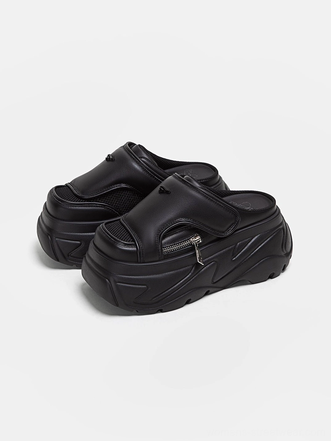 Pair of black platform slide sandals shown from a three-quarter angle with mesh toe panel, silver side zipper, square covered toe, and thick chunky platform sole