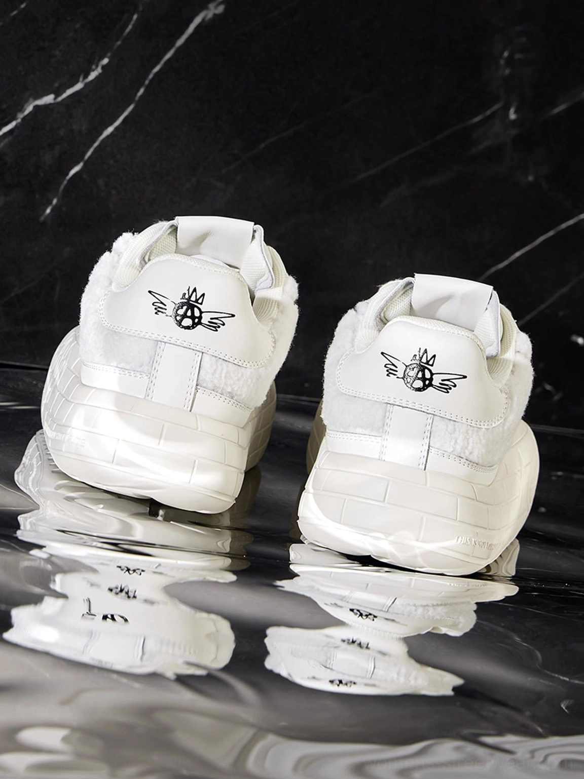 Black platform sneakers with soft fleece upper panels and structured synthetic toe caps