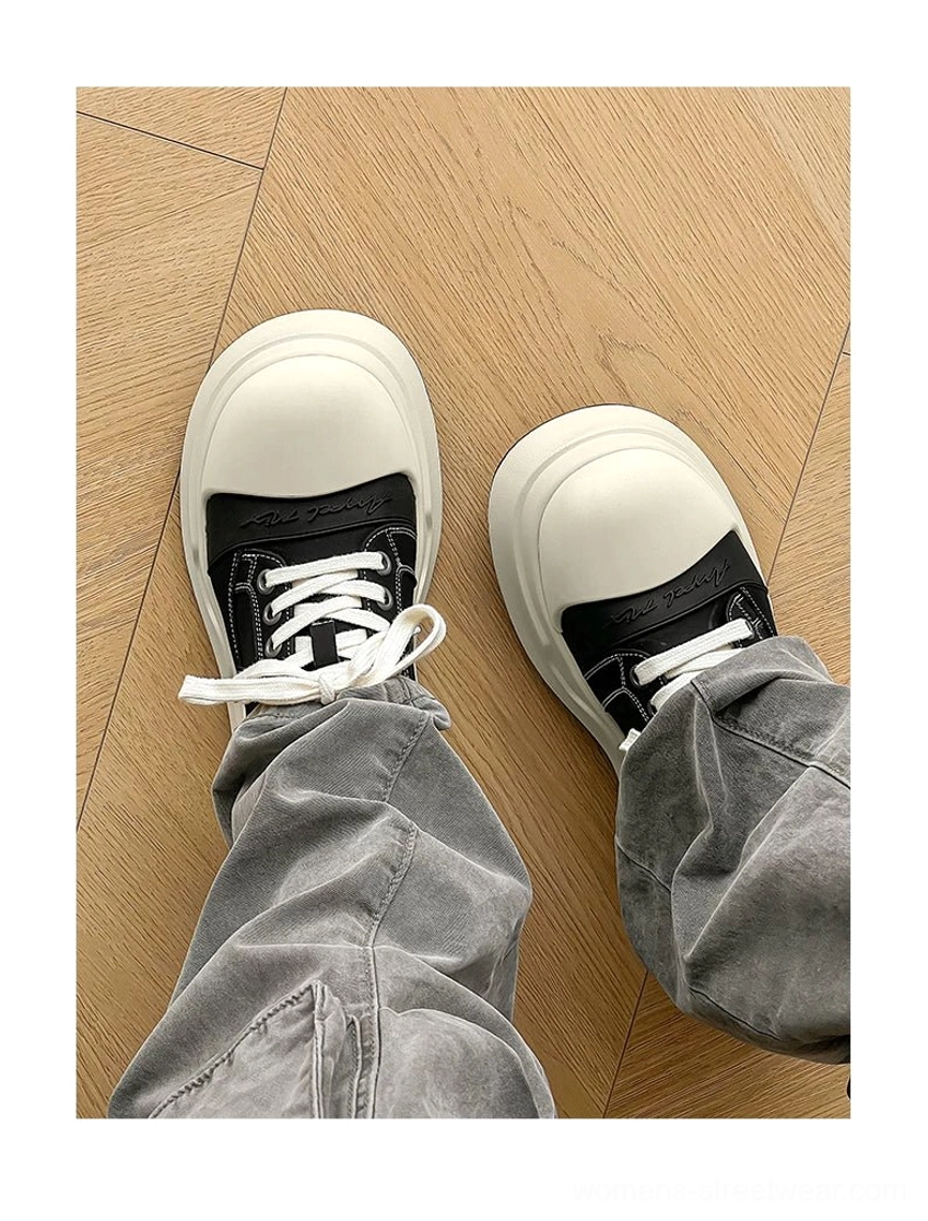 On-foot view of black round toe platform sneakers styled with loose grey cargo jeans for a modern Korean streetwear outfit