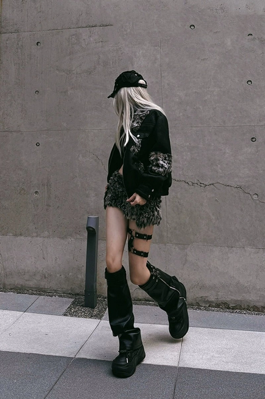 Y2K punk streetwear outfit featuring black platform footwear styled with an all-black look on an urban concrete street
