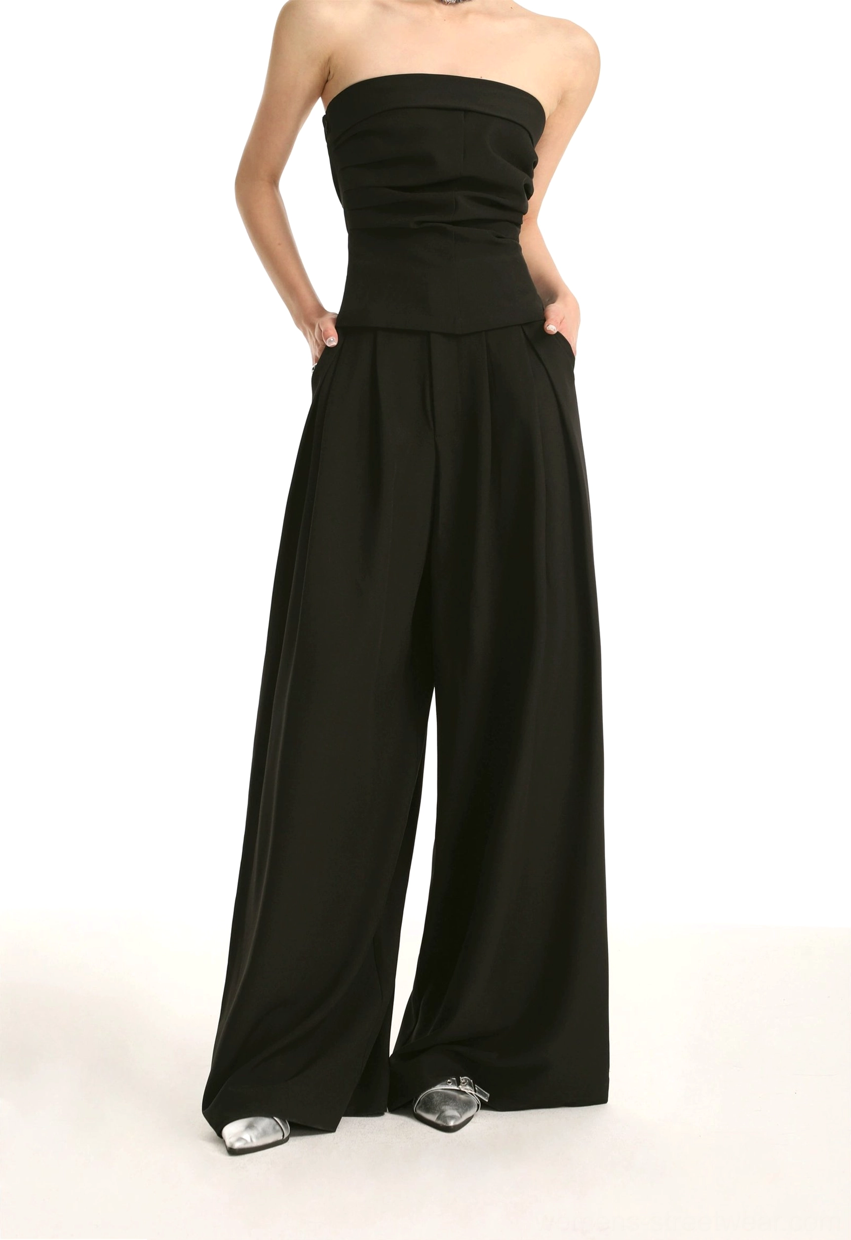 Black high-waist pleated wide-leg trousers with side pockets and ruched strapless tube top side view