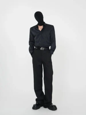 Black point-collar button-up streetwear shirt with open collar styled with wide-leg black suit pants and a silver buckle belt