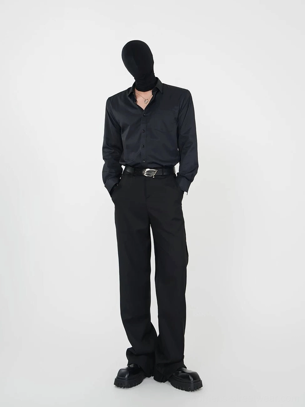 Black point-collar button-up streetwear shirt with open collar styled with wide-leg black suit pants and a silver buckle belt