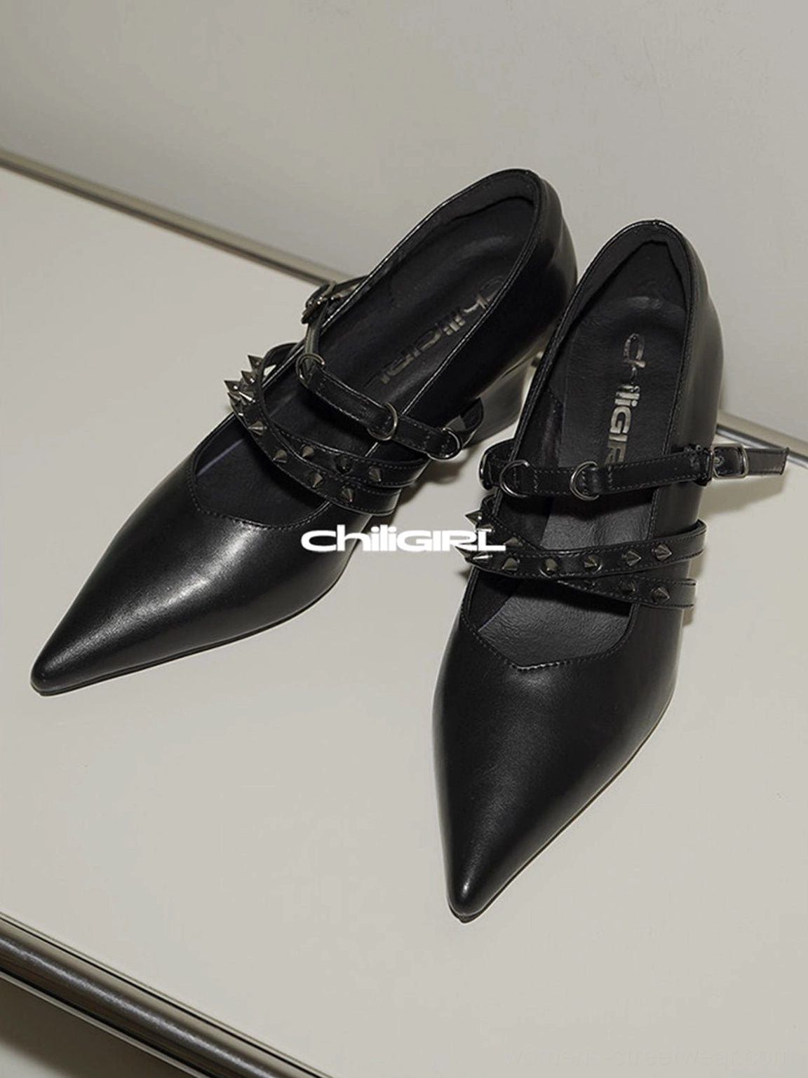 Black pointed toe wedge pumps shown from above with structured dual straps and adjustable buckle details