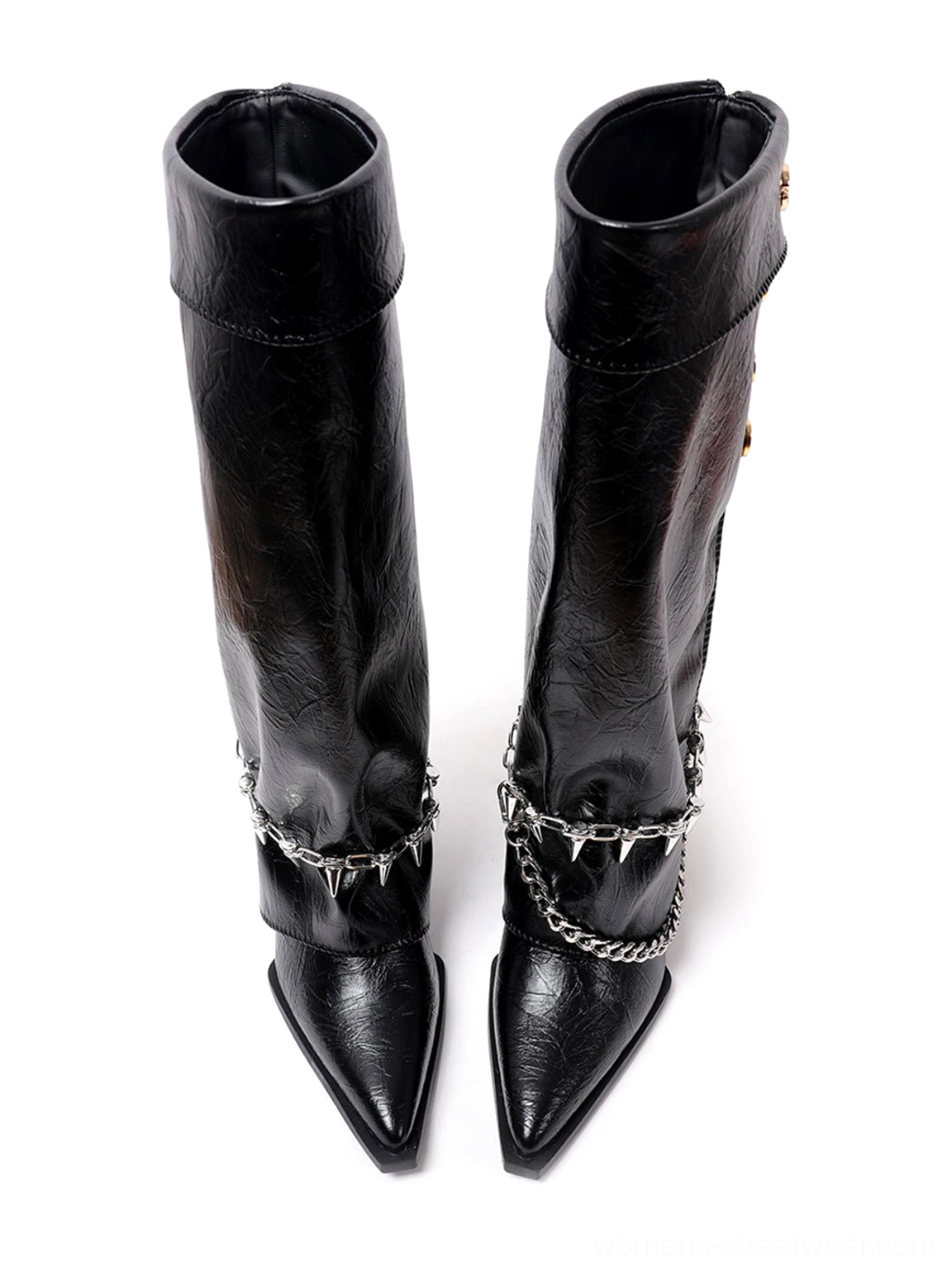 Close-up pair view of black pointed-toe knee-high riding boots with layered spike chain ankle decoration and a sleek low wedge profile