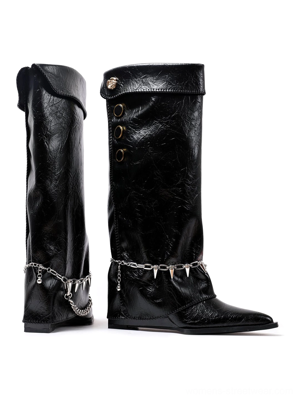 Side profile of black pointed-toe knee-high riding boots with fold-over shafts, metal button fasteners, spike chain ankle hardware, and low wedge soles