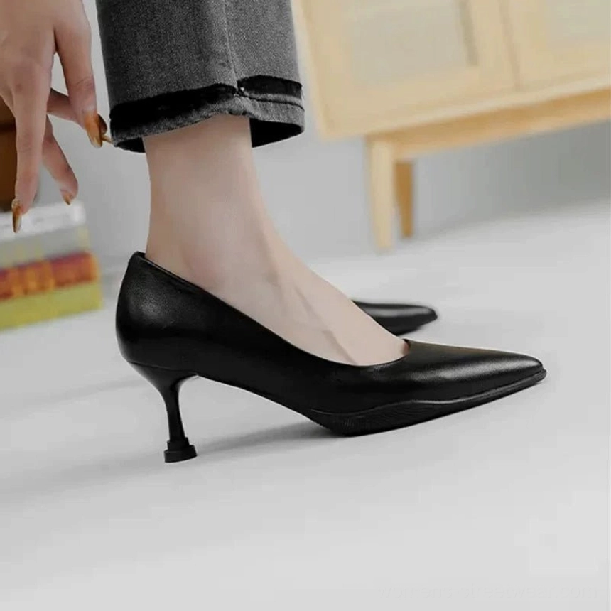 Black polished leather pointed-toe kitten heel pumps styled with cropped dark denim jeans