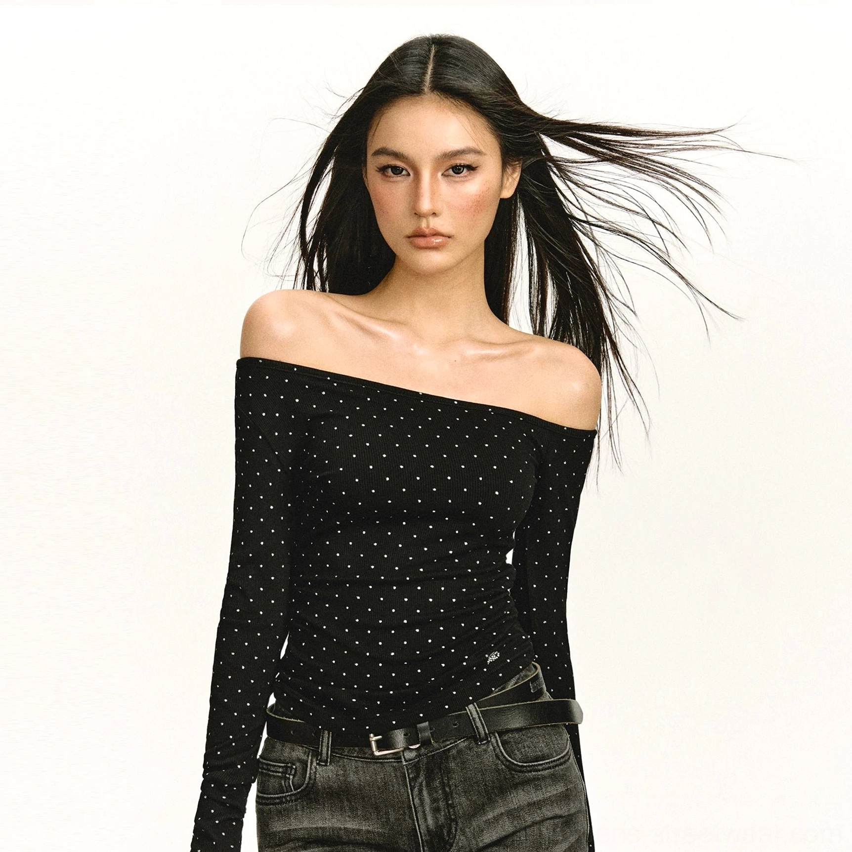 Close-up of black polka dot asymmetric off-shoulder ruched long-sleeve streetwear top