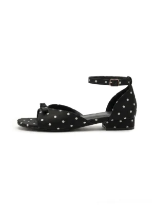 Black polka dot bow ankle strap low heel sandals side view on a clean background