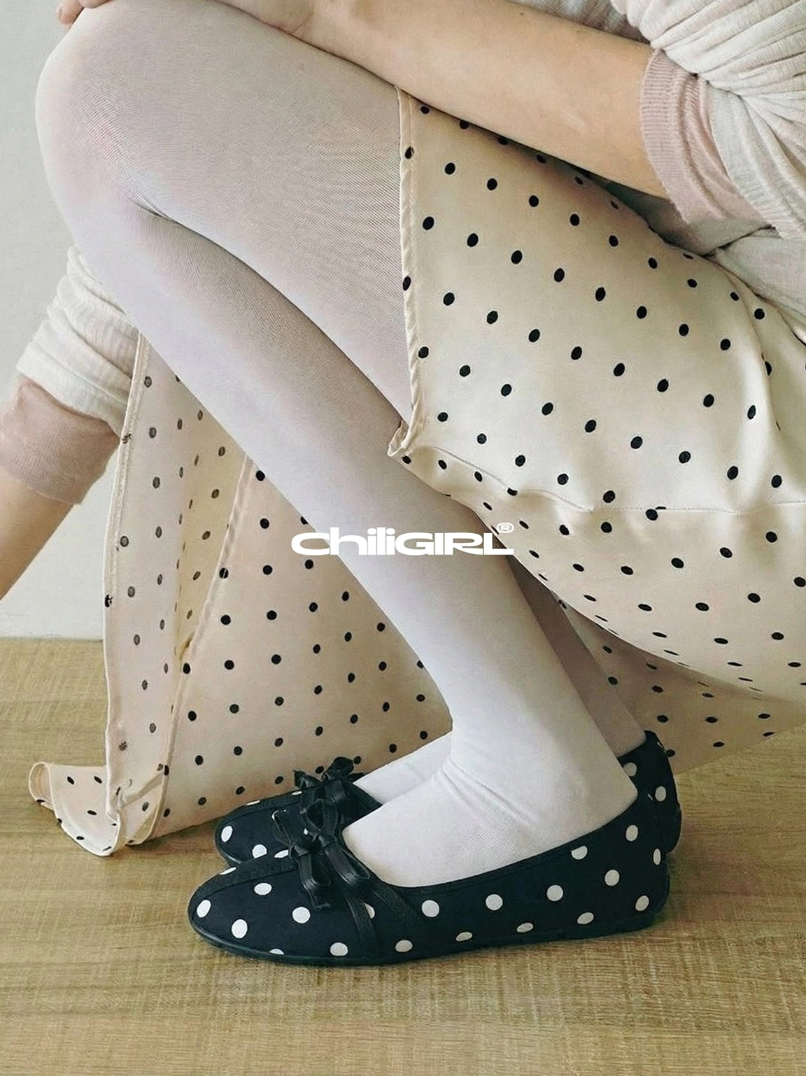 Black and white polka dot bow ballet flats styled with white stockings and a matching polka dot midi skirt