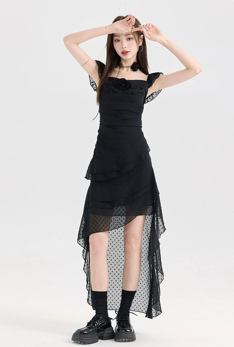 Black polka dot high-low dress with ruffle sleeveless straps, fitted bodice, floral chest ornament, and sheer mesh overlay hem