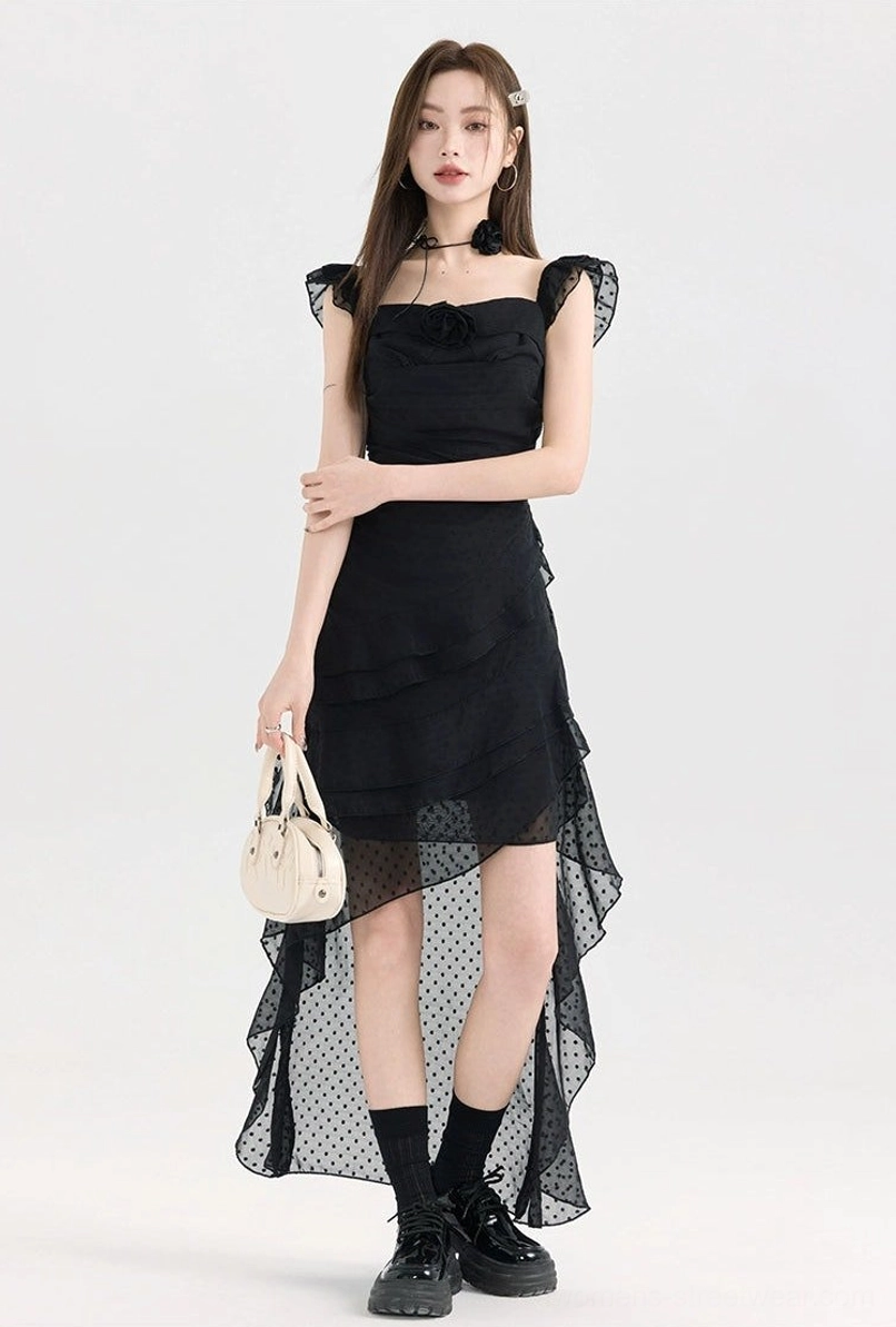 Black polka dot high-low ruffle dress styled with a beige mini handbag, sheer dotted mesh skirt overlay, square ruffle neckline, and asymmetrical hem