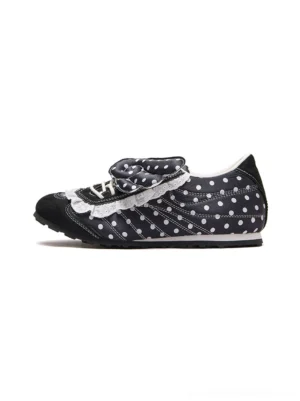 Side studio view of black polka dot lace wing bow ballet flats with white ruffled trim and decorative ribbon panels