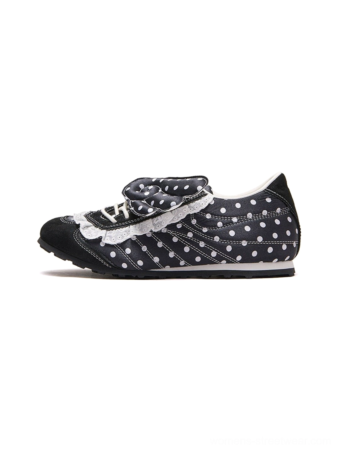 Side studio view of black polka dot lace wing bow ballet flats with white ruffled trim and decorative ribbon panels