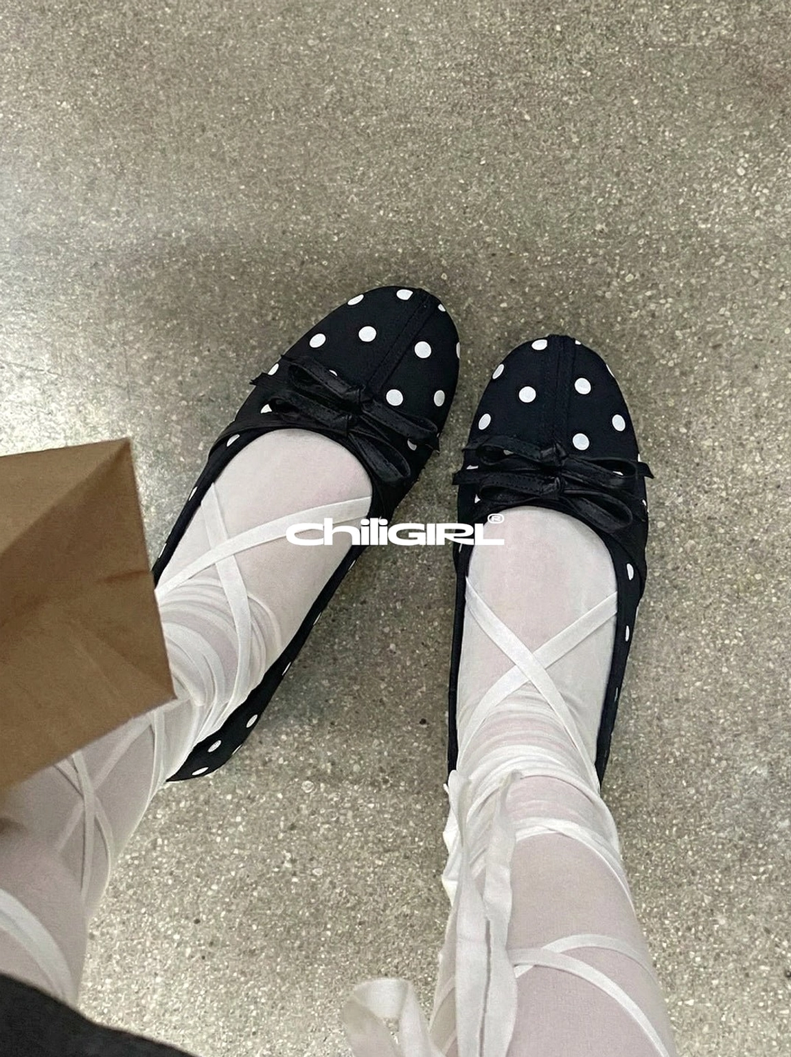 Black and white polka dot Mary Jane ballet flats styled with crisscross white ribbon stockings in a Seoul-inspired streetwear look