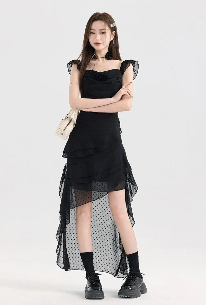 Black polka dot mesh high-low dress shown from the front with fitted waist, layered ruffle skirt, and sheer tulle hem overlay