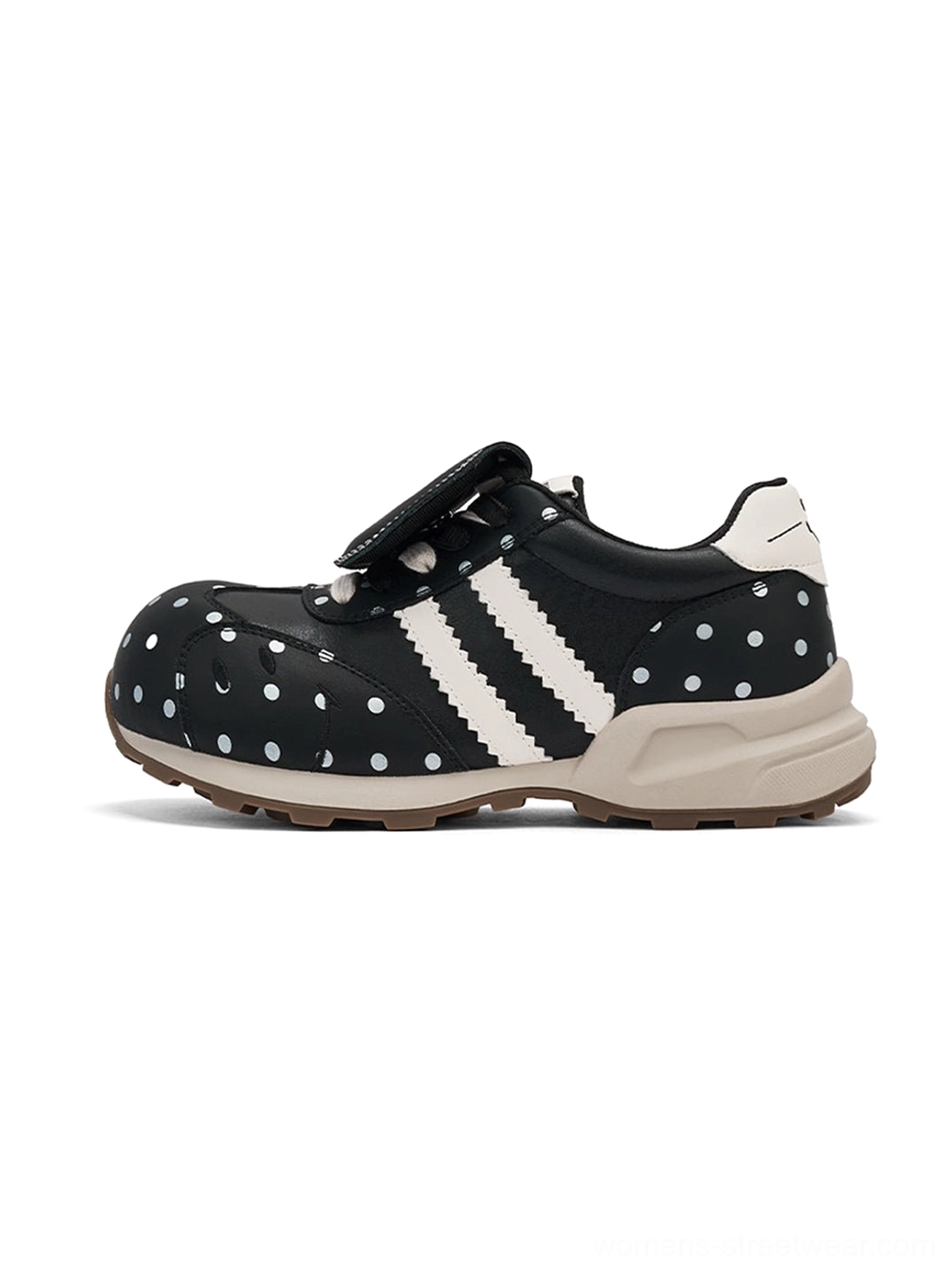 Black polka dot platform sneakers with white side stripes and matching chunky casual streetwear silhouette