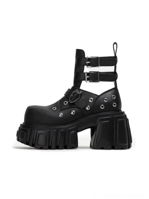 Front three-quarter view of black punk cutout platform ankle boots with multiple buckle straps metal eyelets heart-shaped buckles and chunky lug soles