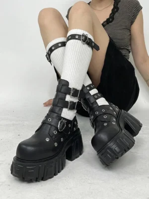 Model wearing black punk platform ankle boots with white ribbed socks striped cropped top and black velvet skirt in a Y2K streetwear outfit