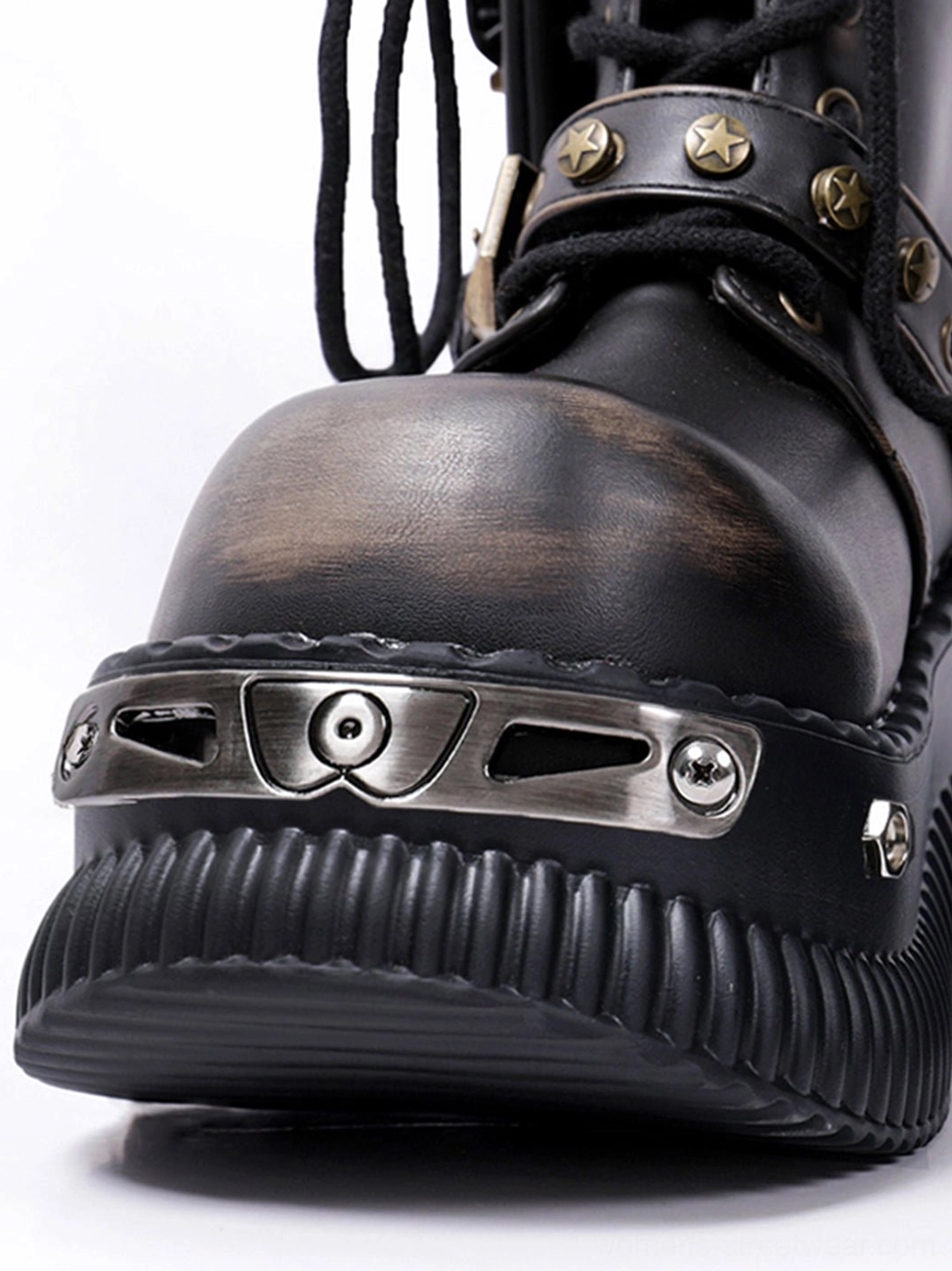 Close-up of black punk platform ankle boot toe with star-shaped metal studs, screw-fixed toe plate, laces, and ridged sole