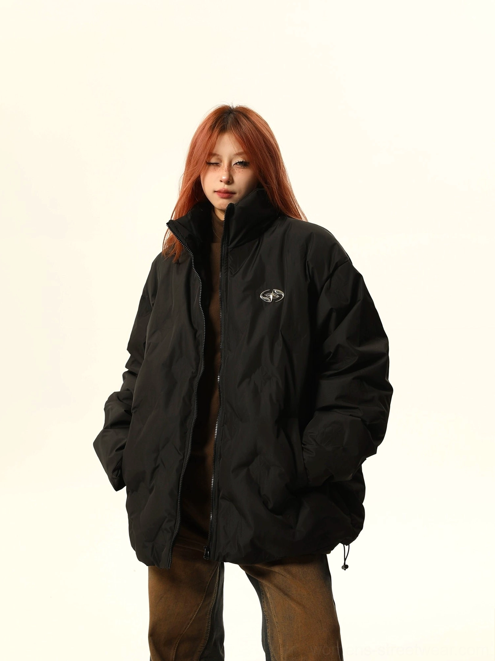 Black oversized quilted bomber jacket with adjustable hem, chest embroidery, and relaxed streetwear silhouette