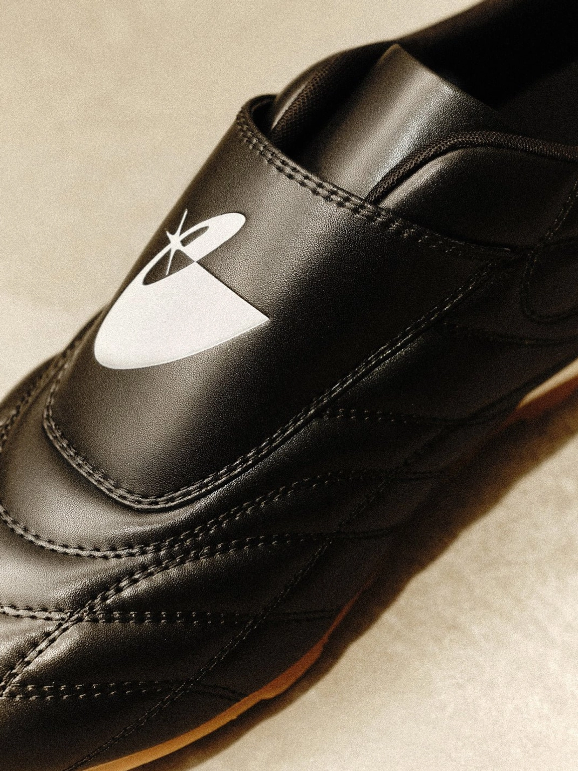 Black quilted football sneakers combining vintage terrace style, modern streetwear detailing, and a slim gum sole