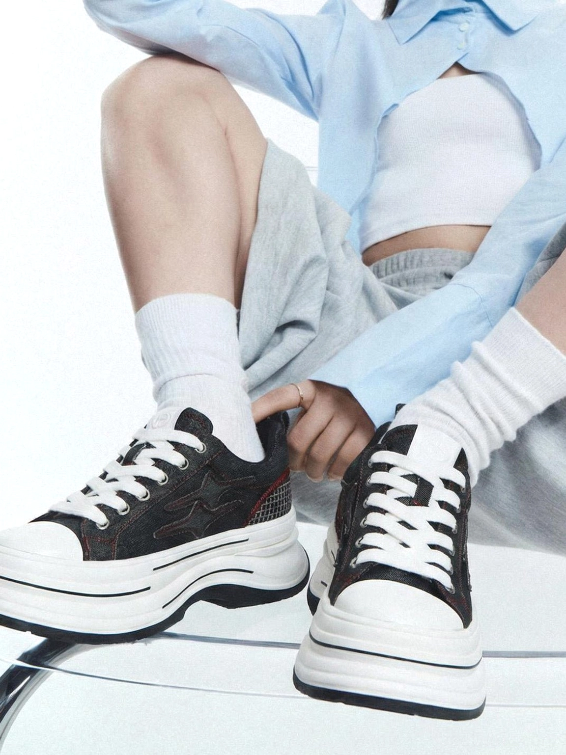 Black red 7cm platform sneakers worn with grey sweatpants and white socks in a low angle Korean streetwear outfit